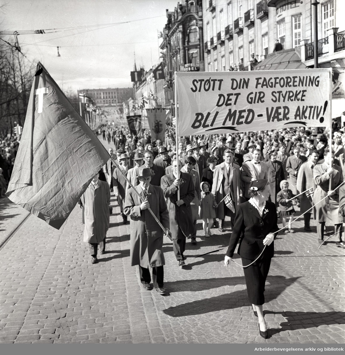1. mai 1958 i Oslo.Demonstrasjonstoget på Karl Johans gate.Parole: Støtt din fagforening.Det gir styrke.Bli med - Vær aktiv!