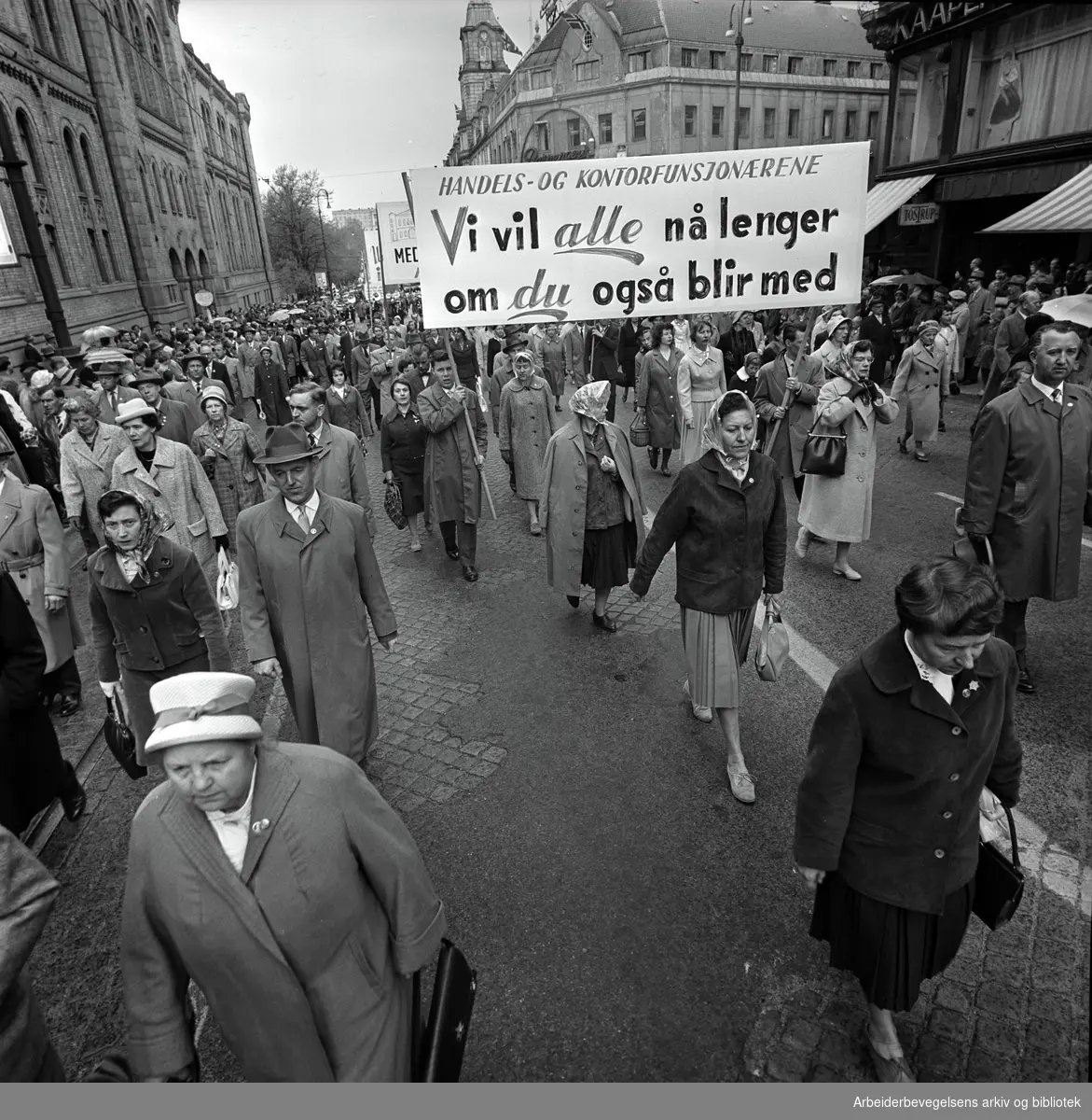 1. mai 1961 i Oslo.Demonstrasjonstoget på Karl Johans gate..Parole: Handels og kontorfunksjonærerne.Vi vil alle nå lenger.om du også blir med.