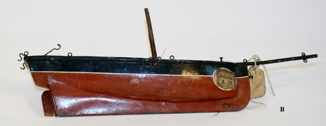 Tre lekebåter, en (B) laget av metall.
