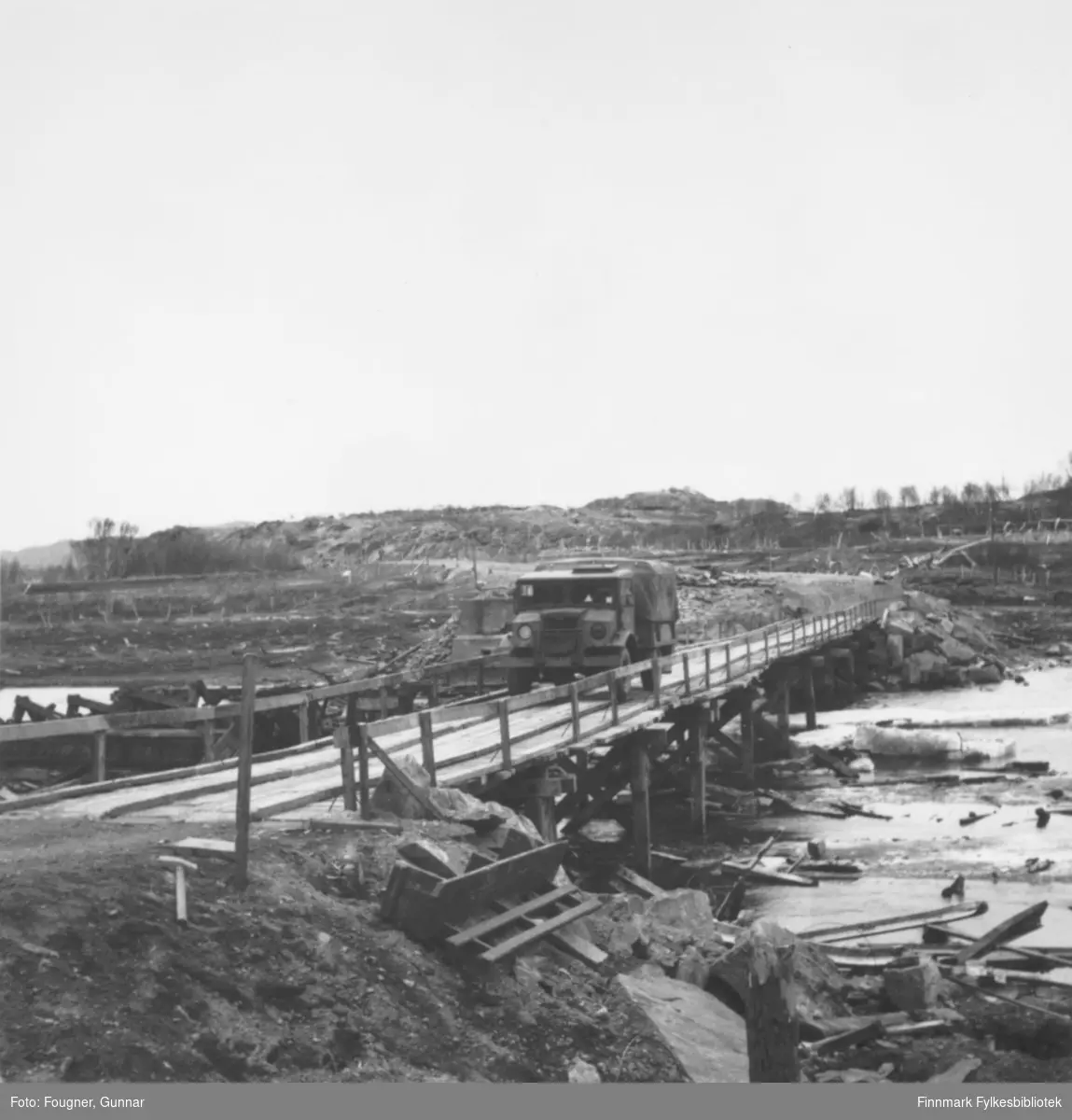 En militær lastebil, Chevrolet, kjører over en bro. Stedet er Brennelv i Porsanger.