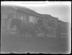En hestekjerre med to kvinner står utenfor den gamle turnhyt