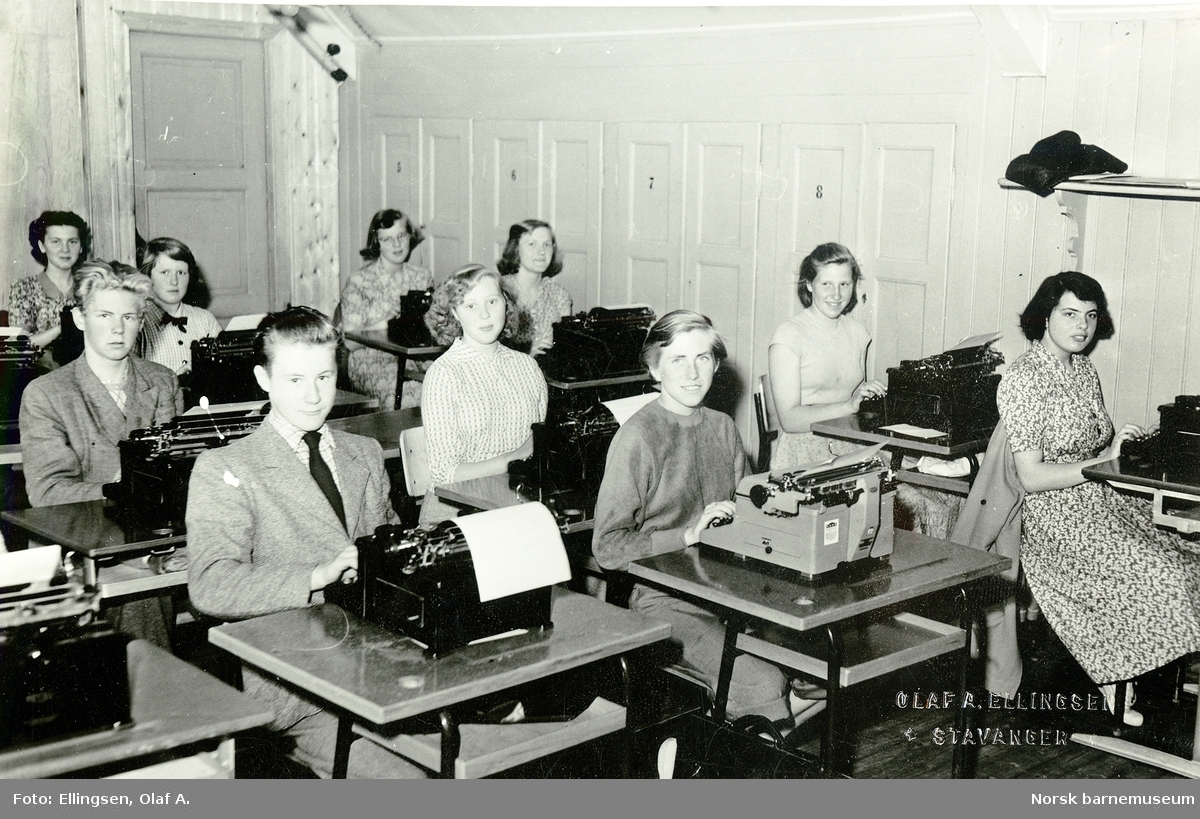 Framhaldsskolen. Bilde fra en skrivemaskintime. Åtte jenter og to gutter skriver på maskin.
