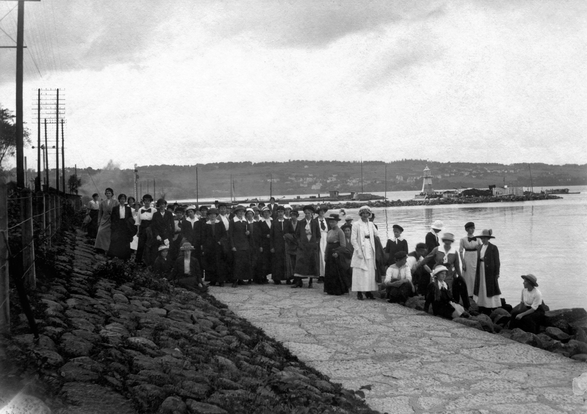 Anna Elming med skolkamrater på utflykt till Strandpromenaden vid Vättern i Jönköping. I bakgrunden syns Jönköpings hamn.