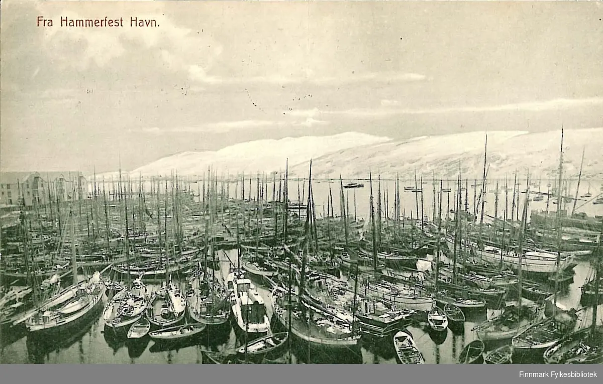 Postkort med motiv fra Hammerfest havn. Kortet er en jule- og nyttårshilsen til Arthur og Kirsten Buck på Hasvik. Kortet er sendt fra Hammerfest i 1910.