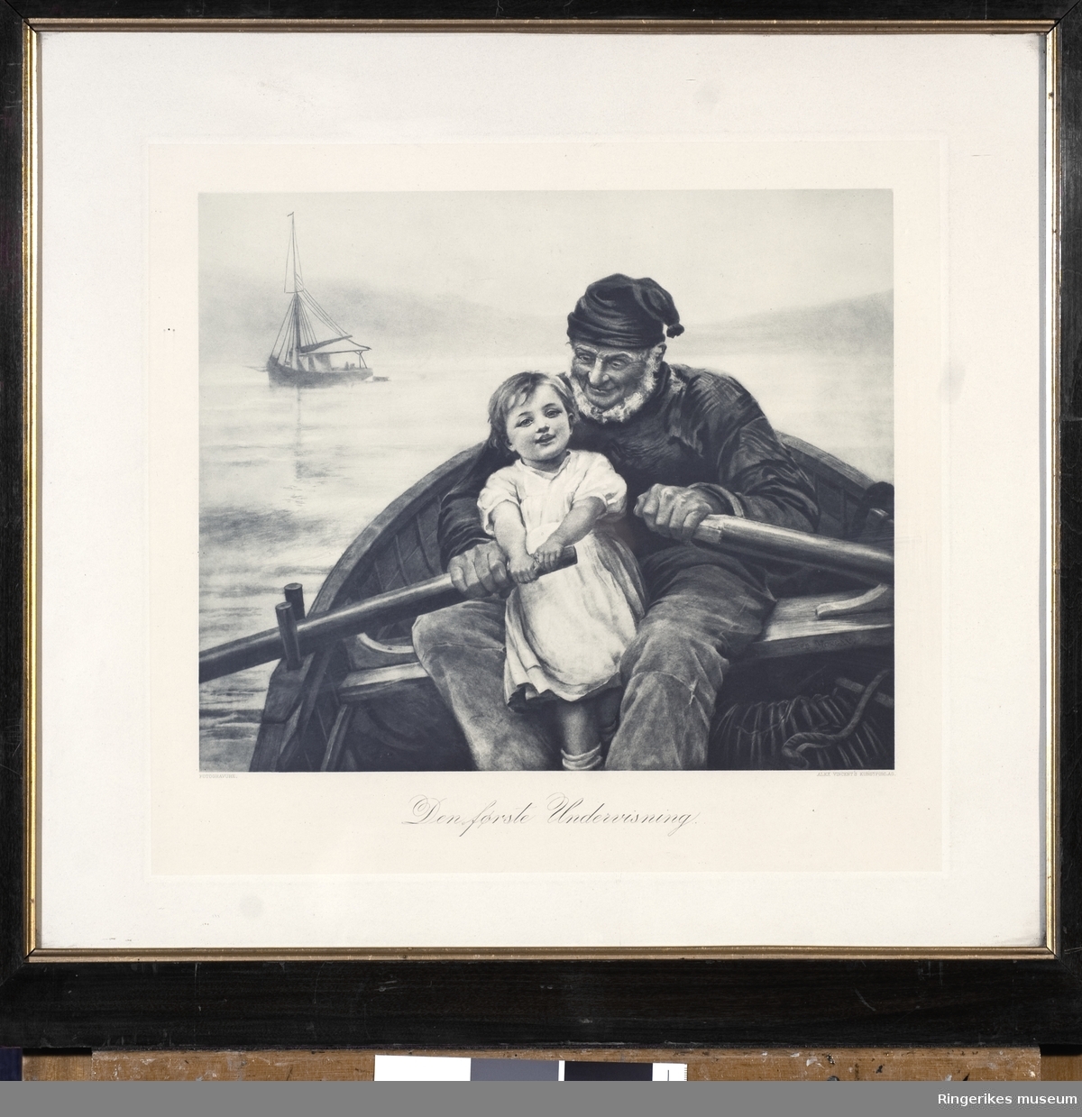 Bildet er et trykk i svart/hvit av en eldre mann som ror på havet sammen med en liten pike. Bildet har tittelen Den første undervisning. Det er signert Fred Morgan. Utgitt på Alex Vincent's kunstforlag. Bildet er i glass og ramme og yttermålene er 55 X 51 cm.