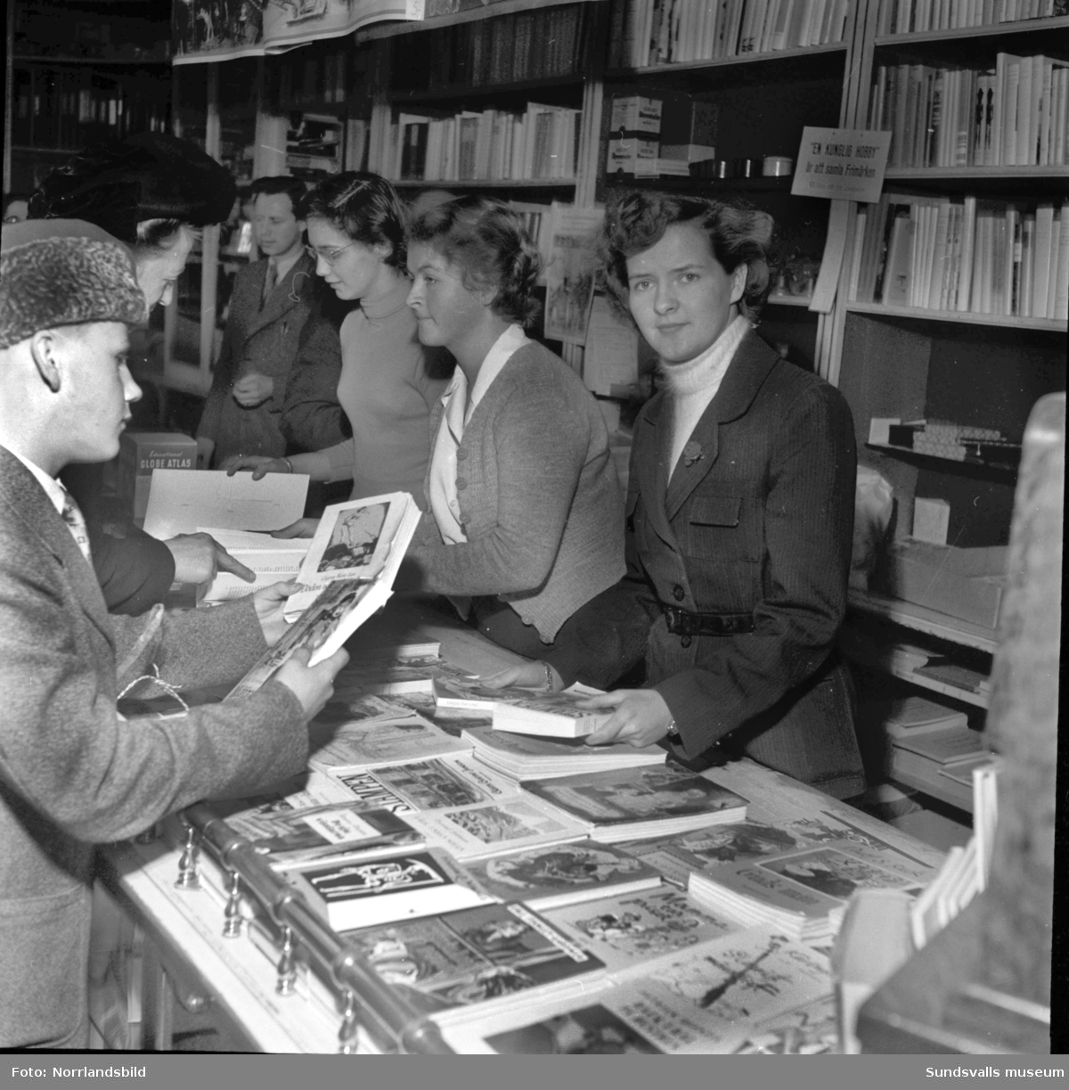 Skolungdom bakom disken på Ahlströms bokhandel.