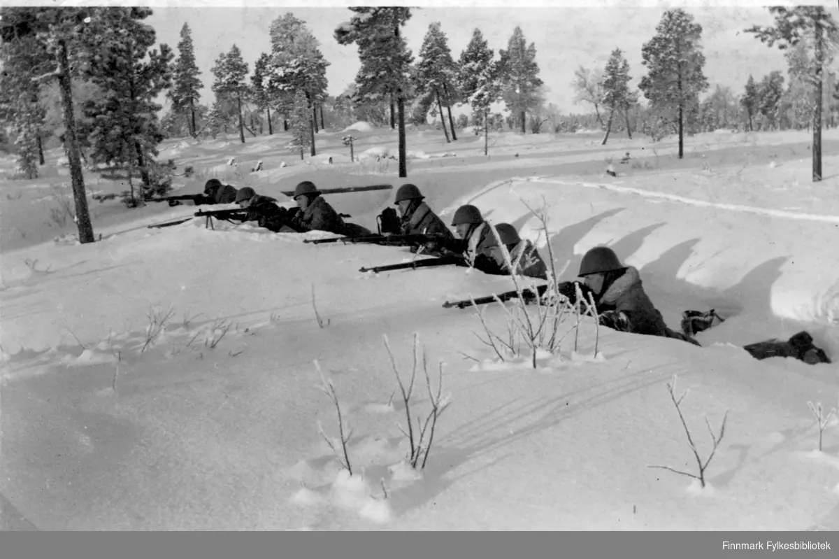 Soldater har øvelse i snøen, flere soldater ligger i skyttergraven og ...