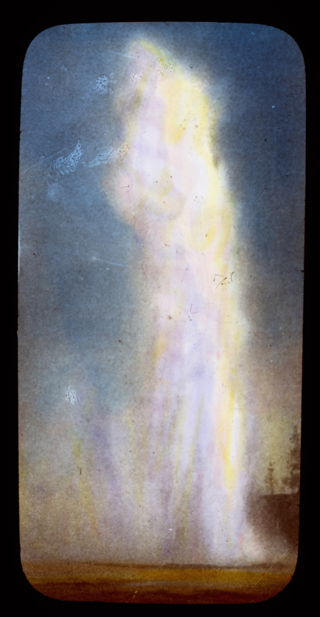 Håndkolorert dias. Avfotografert av ukjent original.Vanndamp spruter opp fra geysiren "Old Faithfull", som ligger i Yellowstone nasjonalpark, U.S.A..