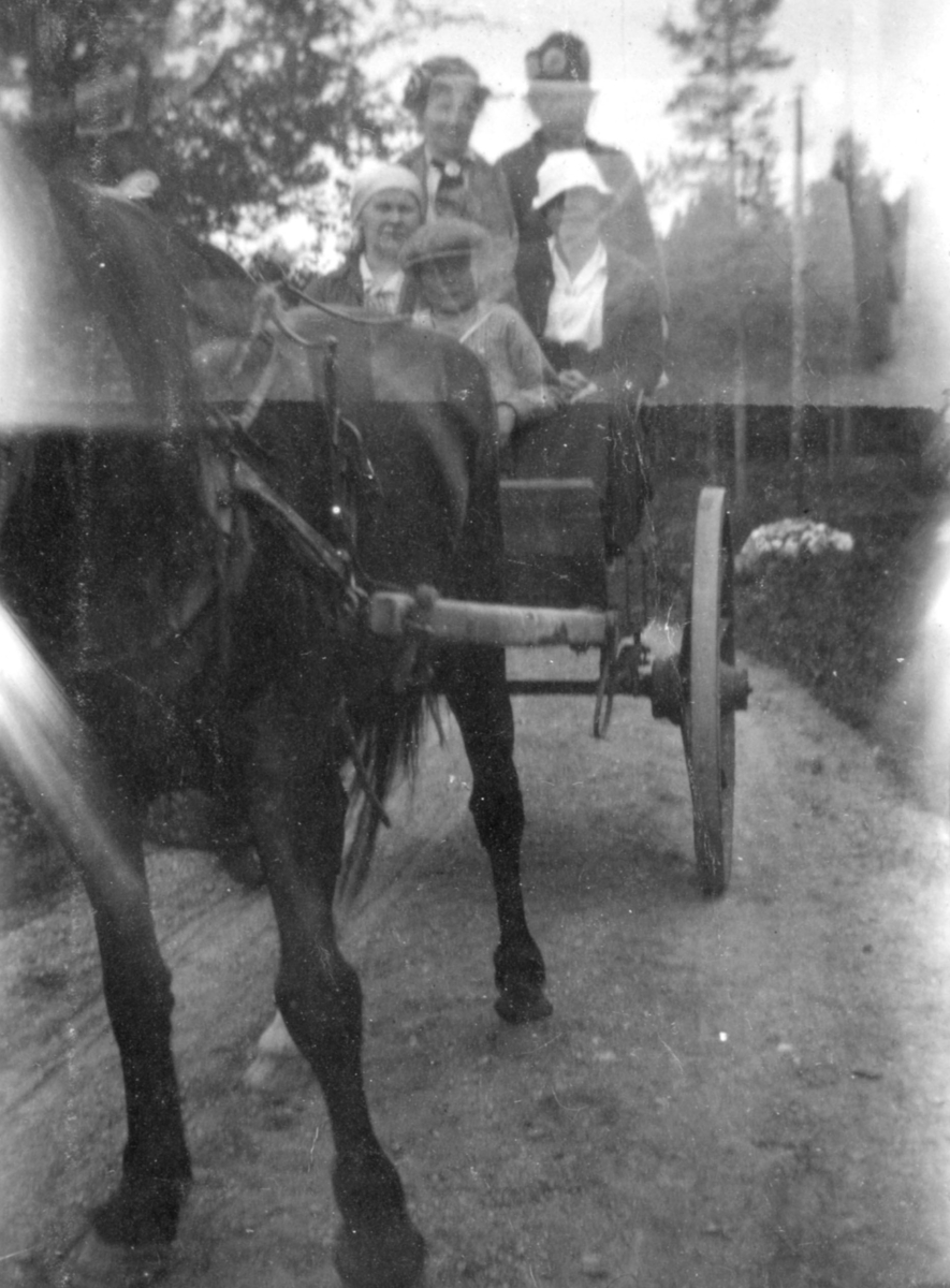 En familie på vei til Russland i 1919. Barn og voksne sitter i en vogn trukket av en hest.