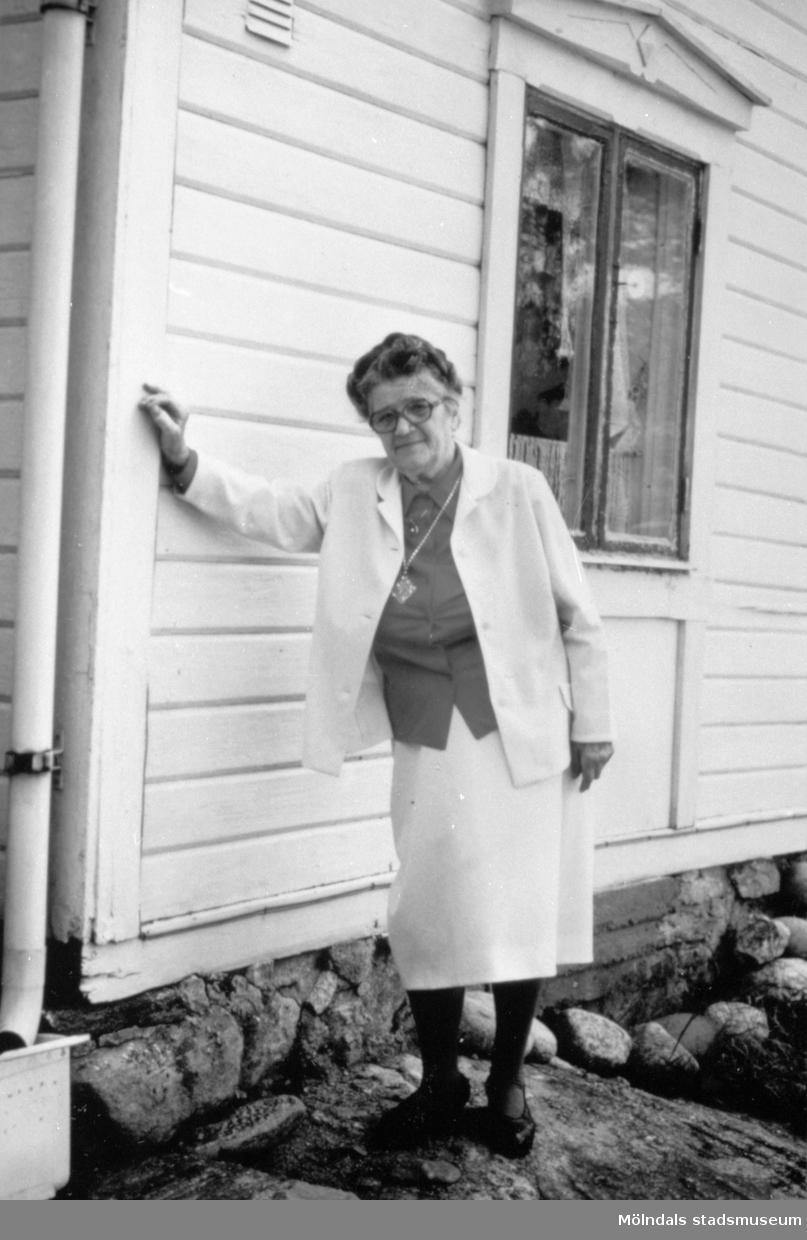 Anna "ve sjön" (Anna Johansson) står och lutar sig mot en husvägg. Bilden är tagen på 85-årsdagen.