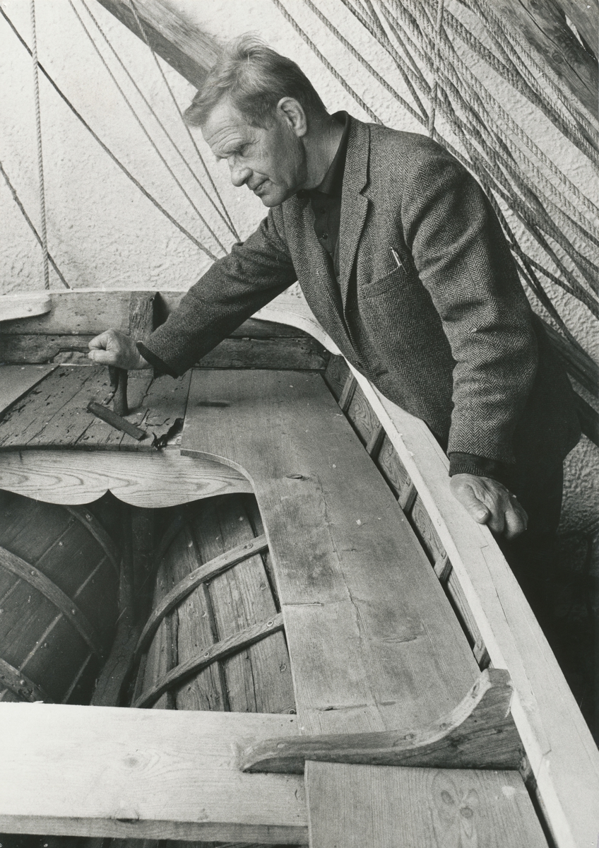 Shetlands-Larsen fotografert ved livbåten han brukte under okkupasjonstiden.