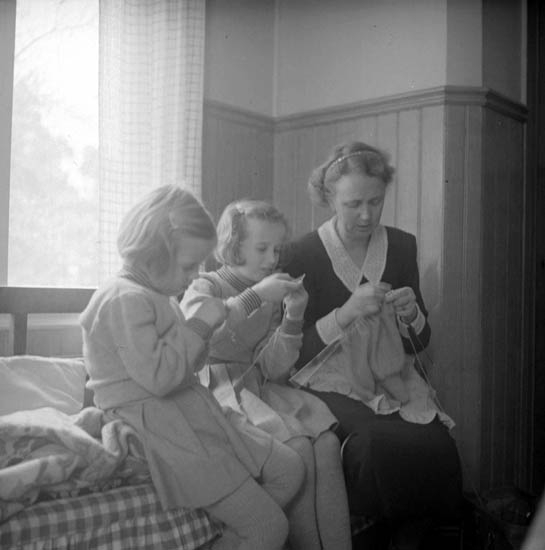 I en lägenhet i Jönköping sitter en mor på kökssoffan med sina två döttrar och lär dem att sticka.