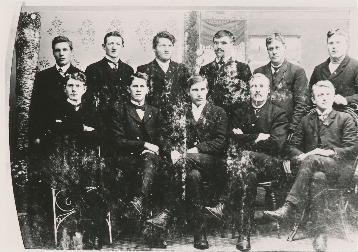 Gruppefotografi av elleve menn der en er identifisert som Johan Blindheim (nr.3 fra høgre i bakerste rekke).