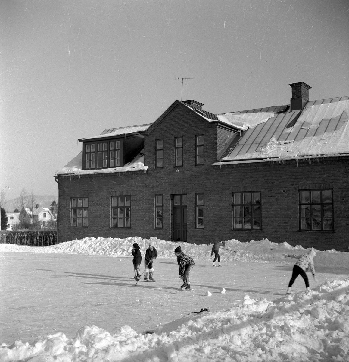 Utanför skolan i Sanna är en isbana spolad och barnen åker skridskor och spelar ishockey.