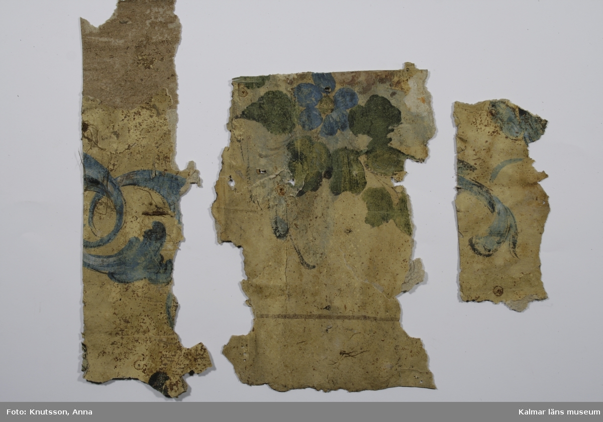 KLM 22792. Tapet i papper. Målad rocailler i blått och blommönster i blått, grönt och guld. Pappersfärgad botten. Datering: 1760-tal.