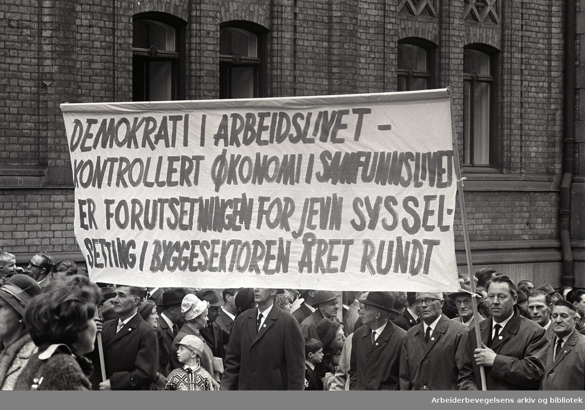 1. mai 1966 i Oslo.Demonstrasjonstoget i Karl Johans gate.Parole: Demokrati i arbeidslivet- Kontrollert økonomi i samfunnslivet er forutsetningen for jevn sysselsetting i byggesektoren året rundt