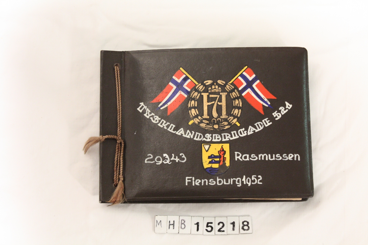 På fremsiden av omslaget på fotoalbumet er det malt to norske flagg, monogrammet til Kong Haakon den 7. Et våpenskjold med et bilde av et tårn.