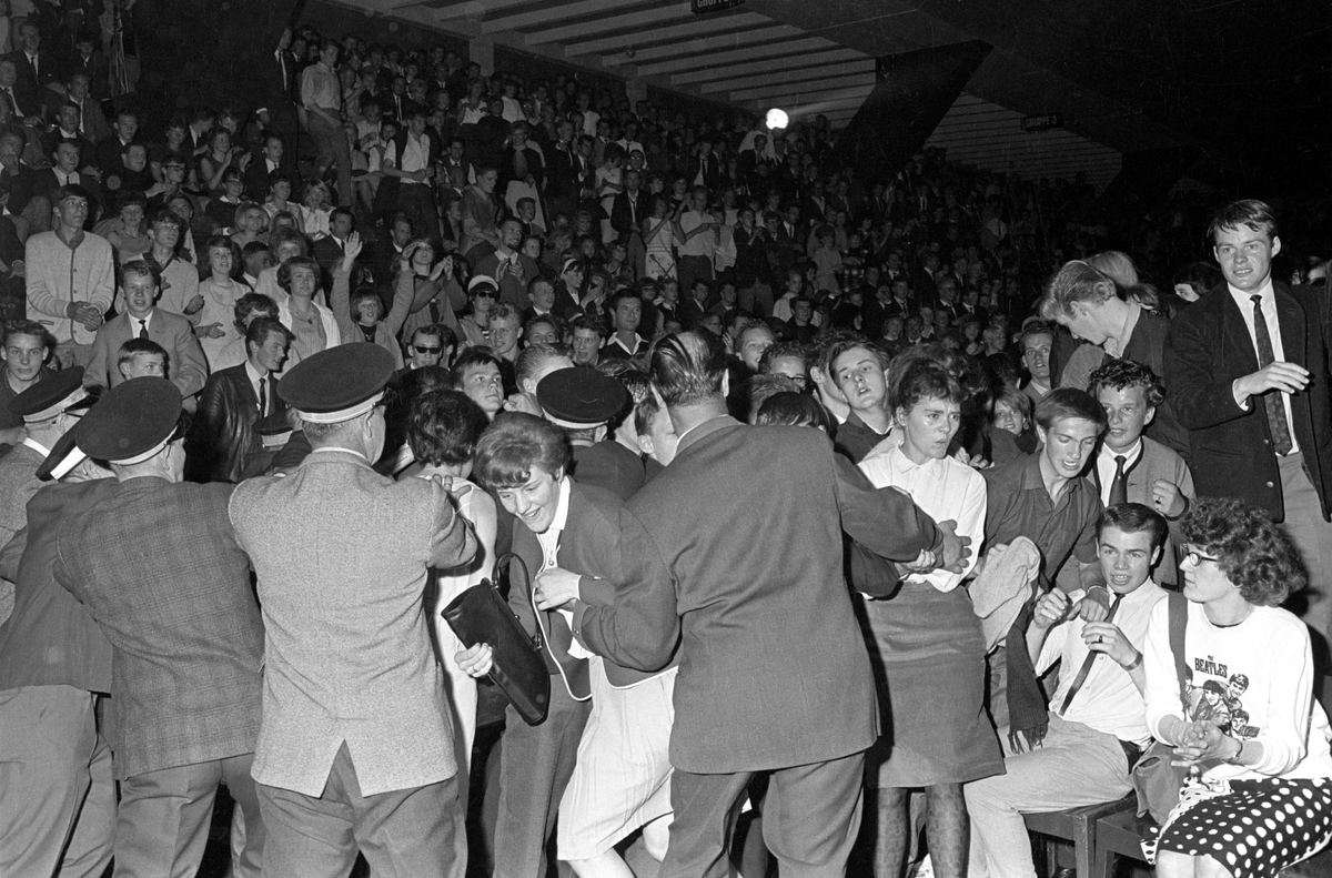 Konsert med det engelske bandet The Beatles i K.B. Hallen i København. Vakter prøver å holde styr på et iverig publikum.
