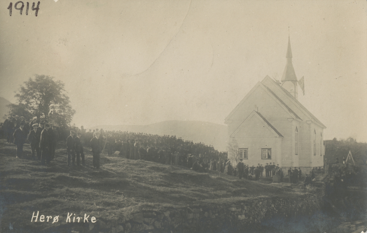 Prospektkort av Herøy kirke med en stor forsamling mennesker utenfor.