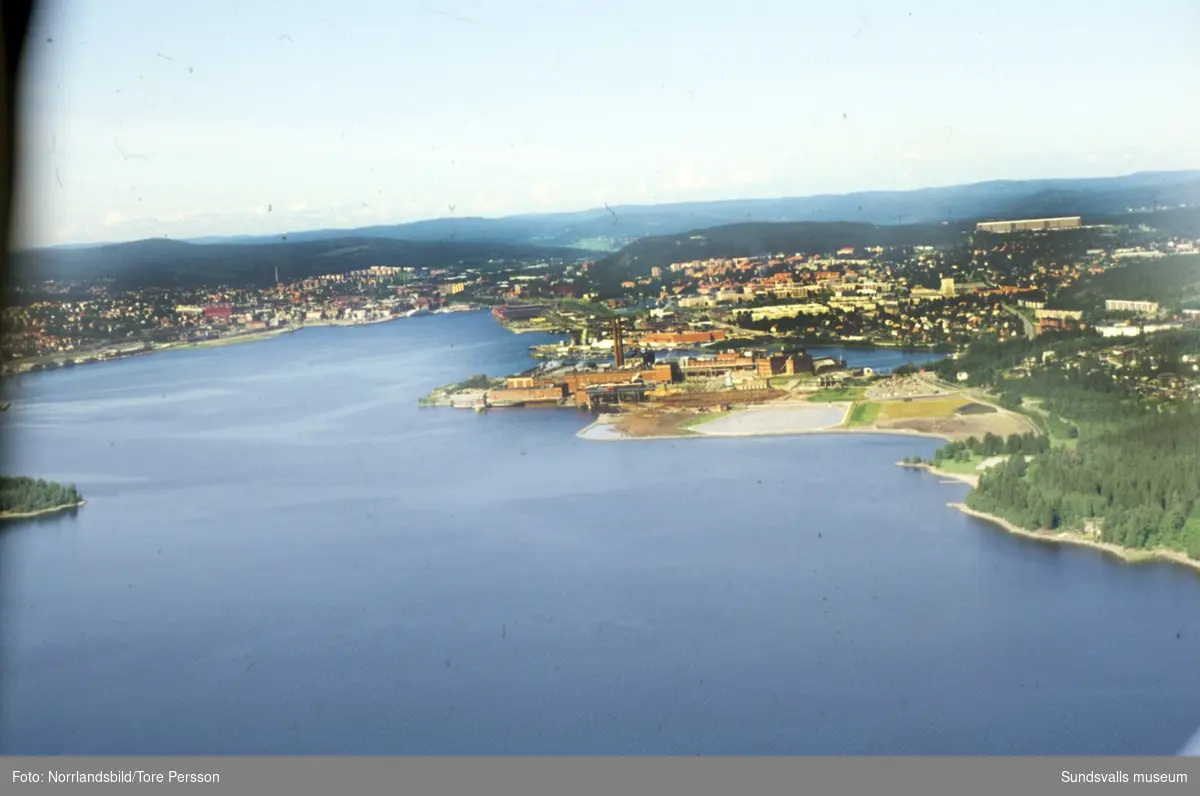 Flygfoto taget från fjärden in mot Sundsvall med Ortvikens pappersbruk mitt i bilden.