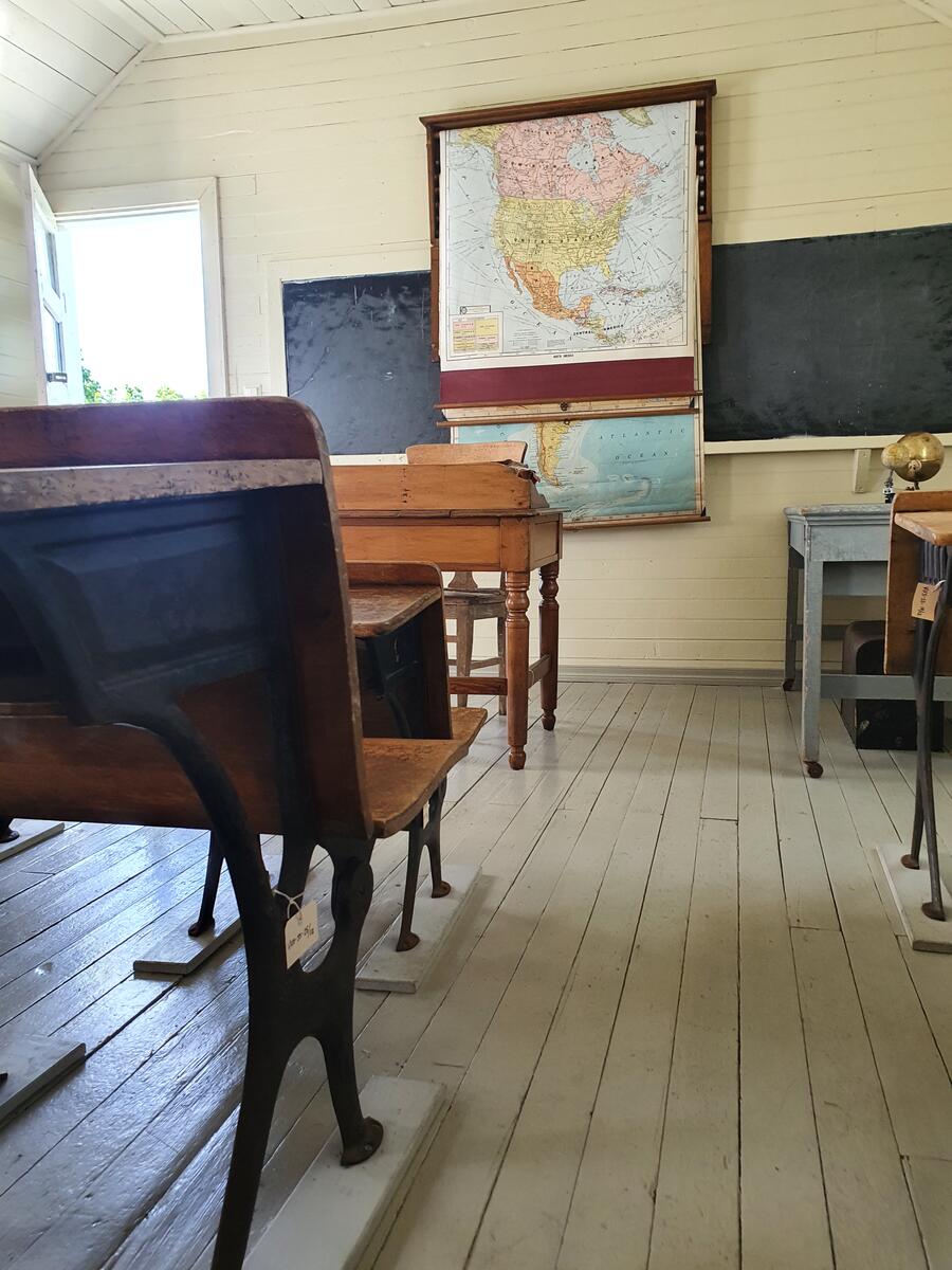 Klasserom i skolestuen, pulter, kart og tavle