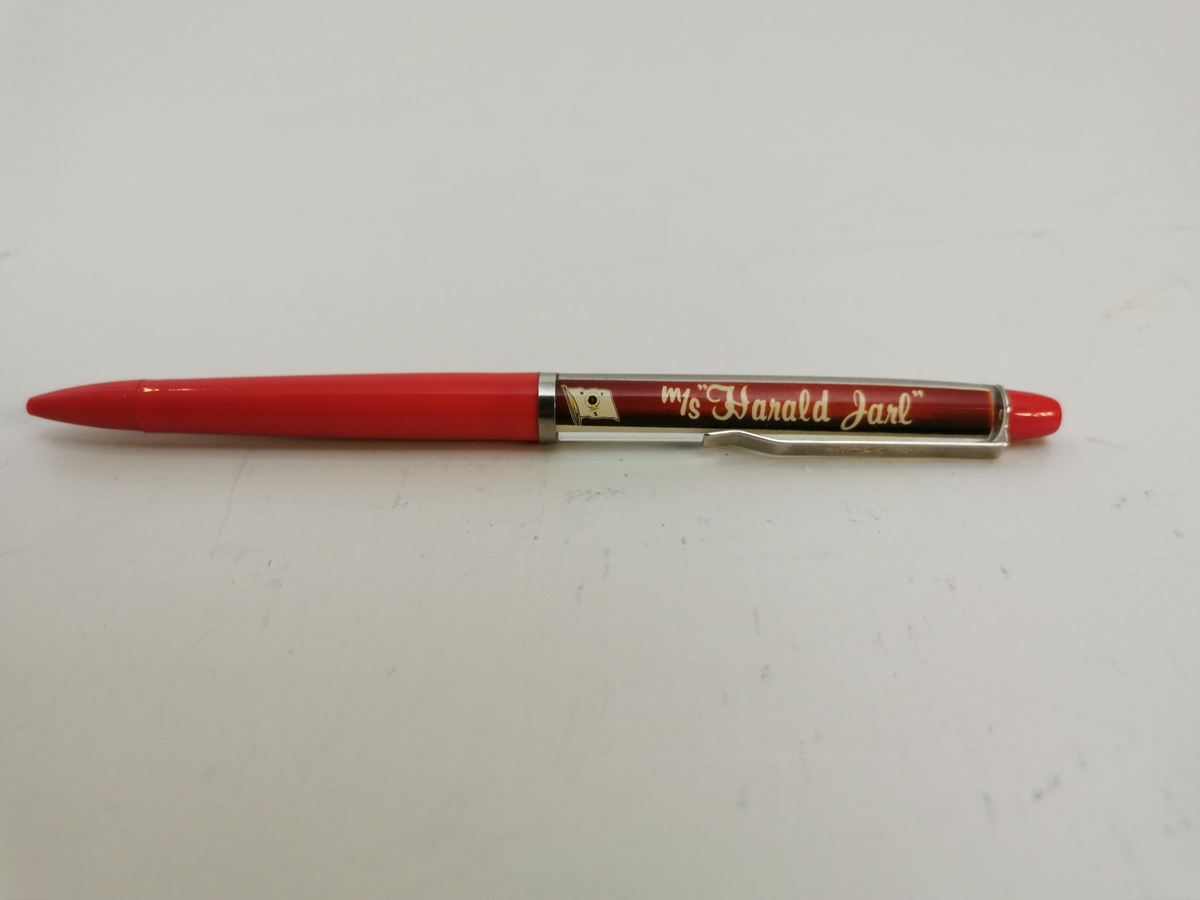 Plastikk penn med modell av M/S "Harald Jarl" flytende frem og tilbake inne i pennskaftet. Metall hempe for å feste i pennen til eventuelt en lomme. Nede på pennen kan du skru pennspissen ut og inn.