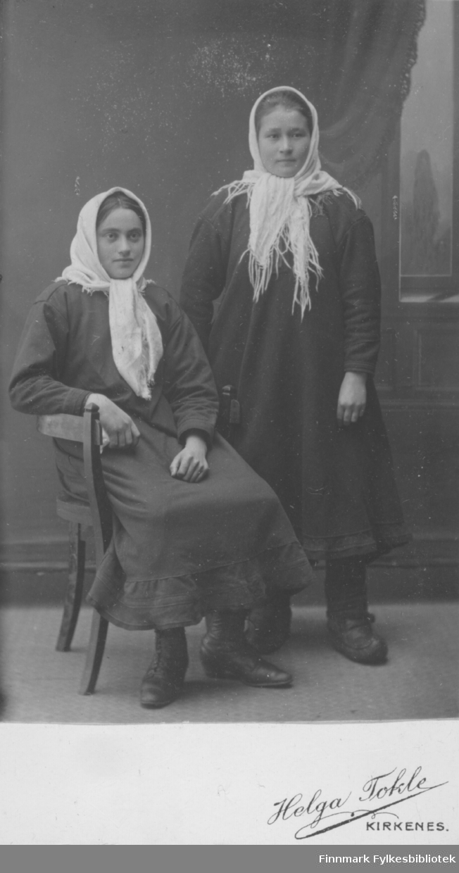 To unge kvinner, kledd i hvite skjerf, i fotoatelier til Helga Tokle i Kirkenes.