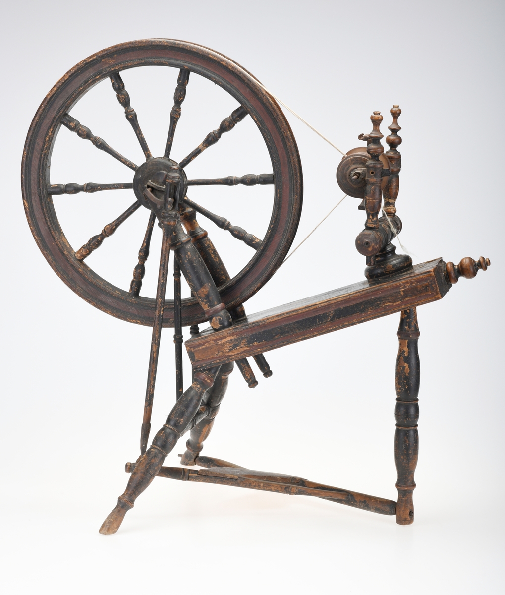 En barnerokk med et pedaldrevet svinghjul med et skråstilt brett (rokkebryst). Det er montert på en vinge/spindel som spinner tråden og en snelle som spoler opp garnet. Rokken drives av en fotpedal.