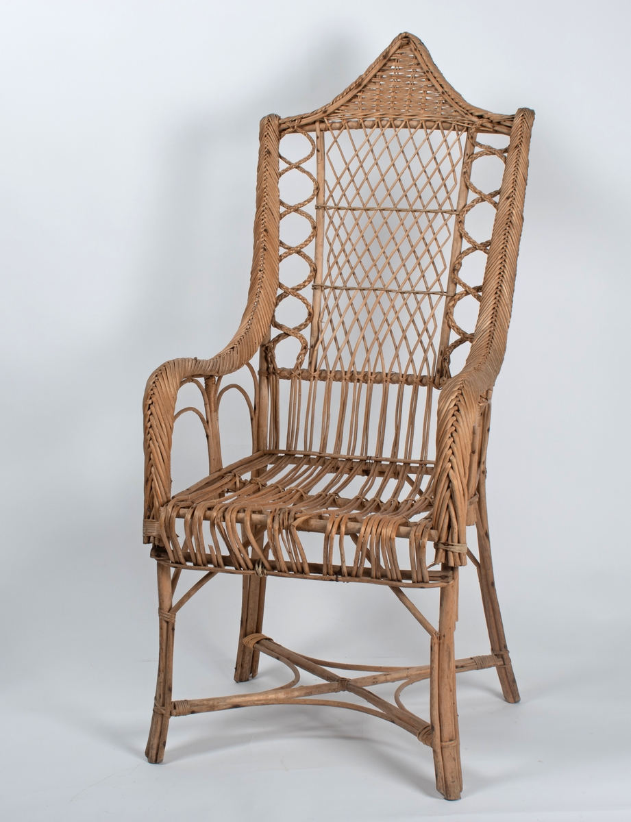 Kurvstol med høy rygg og armlener. Stolen har lett og åpen konstruksjon. Dekorative elementer med ulike typer fletting. Stolen har løs setepute og en liten, løs ryggpute.