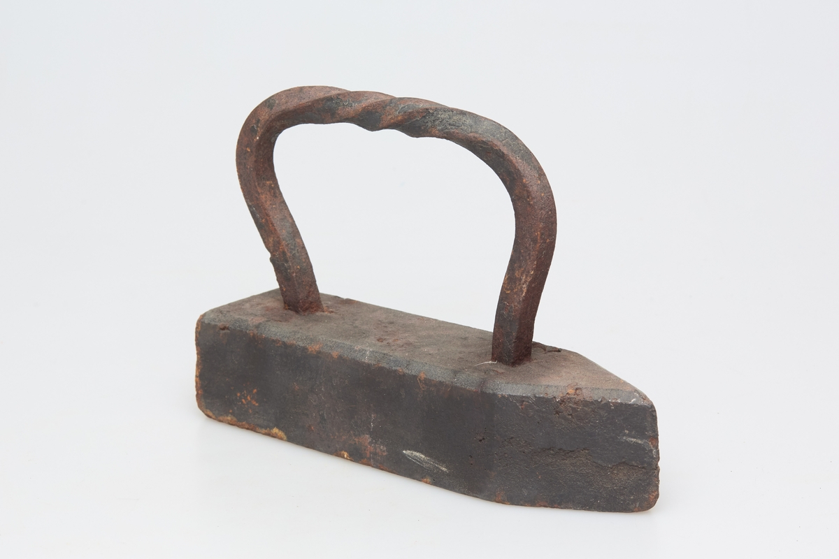 Handtak laget av en firkantet jernstangsom er vridd, formet til og støpt fast i jernet.