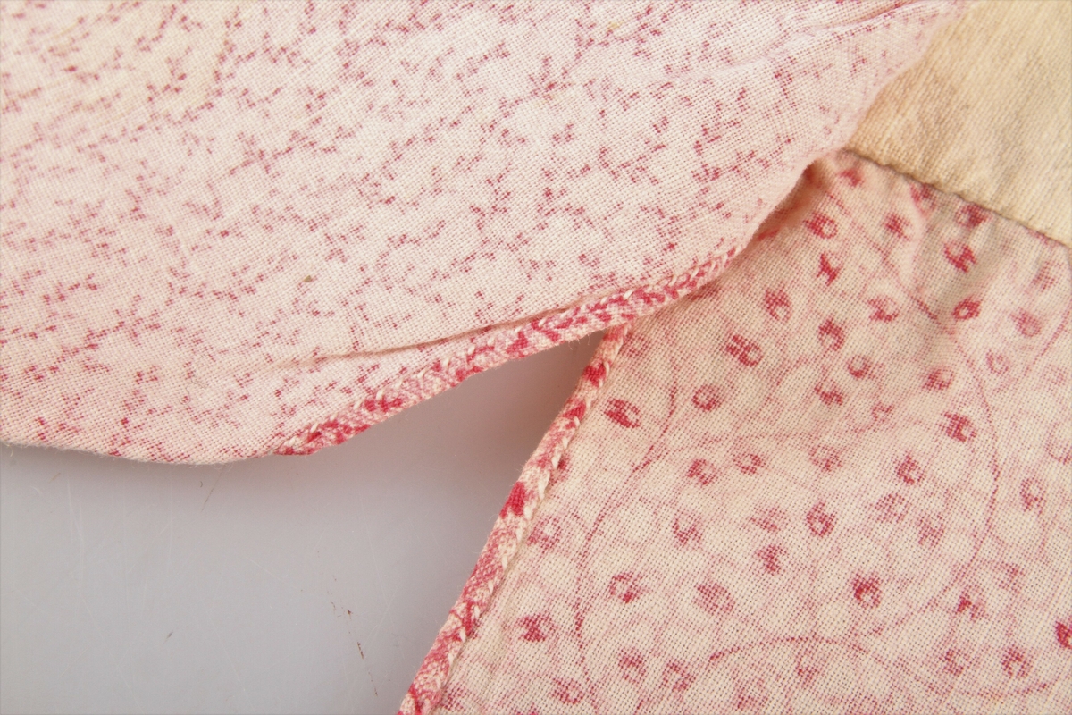 Jakka er sydd av fem ulike rosa bomullstoffer - kattun. Ermene og øverste del er fóret med lin. Den har primærsnitt med åpning foran og i sidene helt opp til armhulen. I halsen er det to sett med knytebånd og ett nederst på ermene. Hele jakka er sydd for hånd med hvit lintråd. 