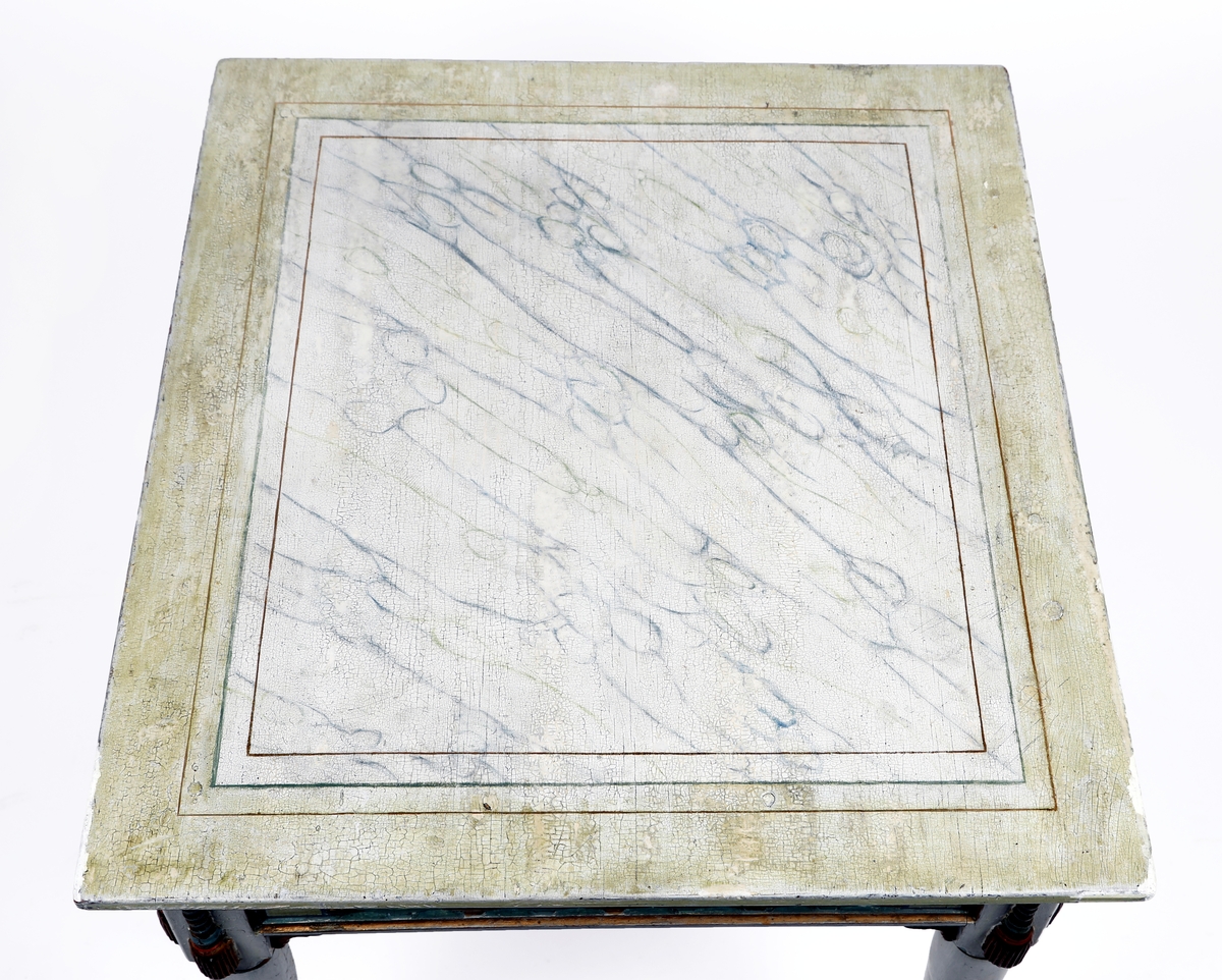 Rektangulært bord med betegnelsen Baldishoel-bord i protokoll. Bordplata malt med imitasjon av marmor og med gullstriper. Sarg med sirkel-ornamenter. og snor-imitasjon med dusk. Har mahognyrødt malingslag under det lyse. Se kons.rapport