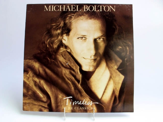 Skivomslag till Michael Boltons LP-skiva "Timeless, the classics".
På framsidan ett porträtt av artisten i svartvitt samt text i vitt med artistens namn och skivans titel.