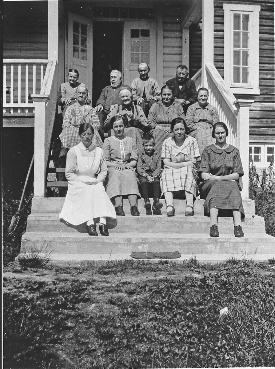 Beboere og ansatte på trappa til gamlehjemmet i Sigdal (nåværende Folkemusikksenteret i Buskerud), ca. 1925. 