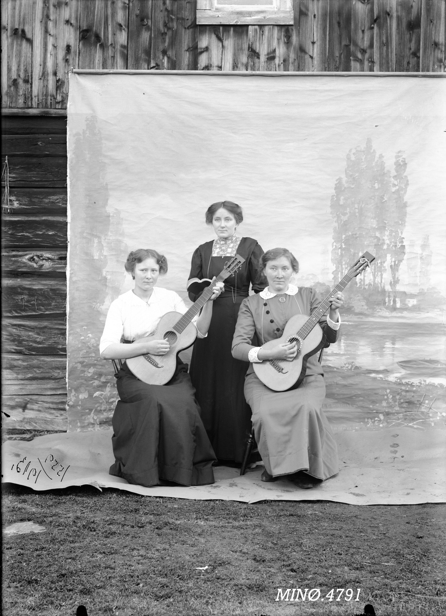 Tre kvinner, to spiller gitar