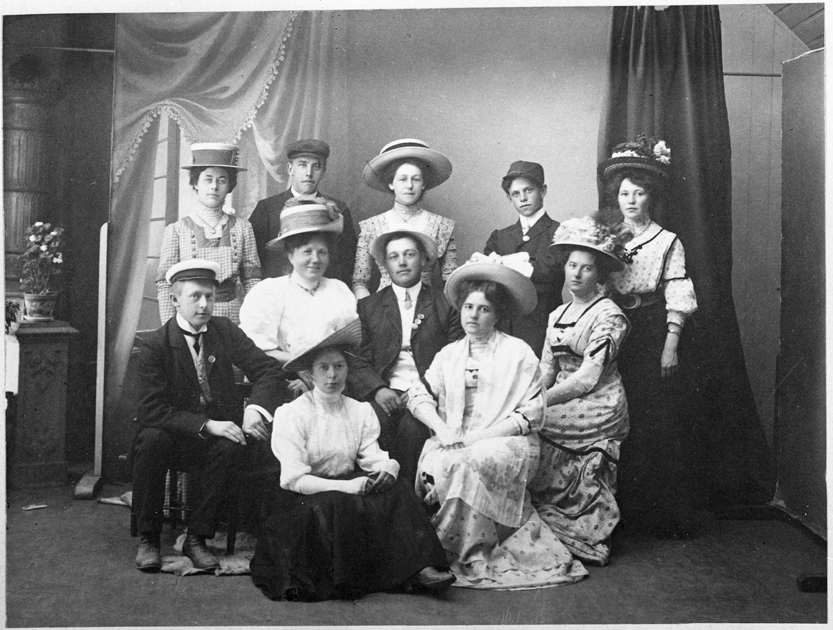 Gruppebilde. Sittende foran med mørkt skjørt er Erna Gihle. Sittende bak: Oscar Narum, Kathinka Larsen, Arne Aarsby, Dora Balke (f.1887), og Hilda Balke (f. 1882, g.m. Arne Aarsby). Stående: Frk. Pettersen (Ellen? Kan evt. også være søstera Ingrid)), Alfred Balke, Magnhild Aarsby (g.m. Erling Bjørklund), Even Gihle, og Borghild Lie (f.1882).
Komm. skrevet av Solveig Aarsby: "Jeg er ikke helt sikker, men en gang ble det nevnt at damene hadde kjøpt seg nye hatter, og derfor ble det fotografi. Erna og Dora har spesielle vanter, og karene har "merke" på jakka".