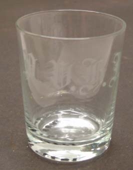Ofärgat glas med vita graverade initialer: "NVHJ".