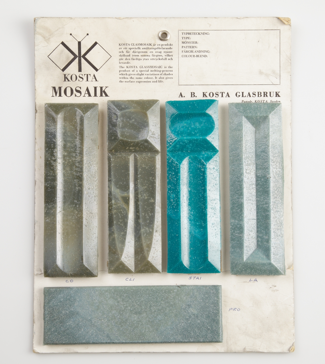 Färgtavla på Kosta Mosaik. 5 rektangulära mosaikbitar i grått och gråblått. Måtten 145x45mm anger måtten på varje mosaikbit.