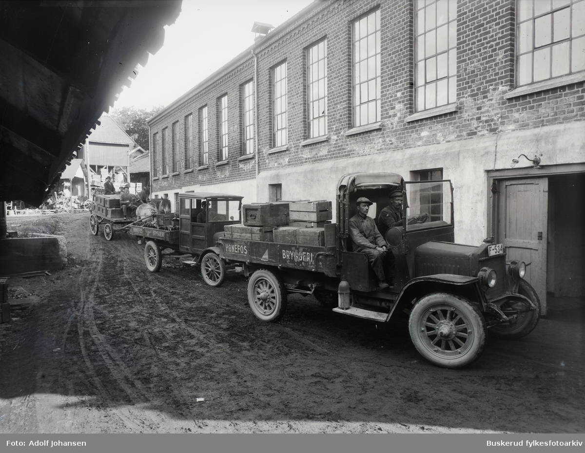 Hønefoss bryggeri med bryggeribiler. Bryggeriet startet opp i 1854. Bygningene ligger i direkte tilknytning til Søndre torv i sentrum av Hønefoss.
Lastebil F-534 en  Denby på bryggeriet.  Bak en Ford TT, lett kjennelig på tverrfjæra over bakakselen. Modellen kom på markedet i 1917