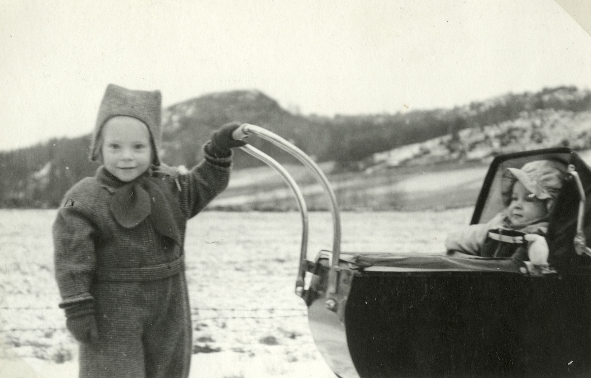 Eva Pettersson (född 1944, gift Kempe) kusinen Stina Krantz i barnvagn år 1946. Vommedal och Brattåsberget ses i bakgrundens mitt. Eva är dotter till Bror och Rosa* Pettersson (född Krantz). Stina är dotter till Edit och Östen* Krantz.
*Syskon