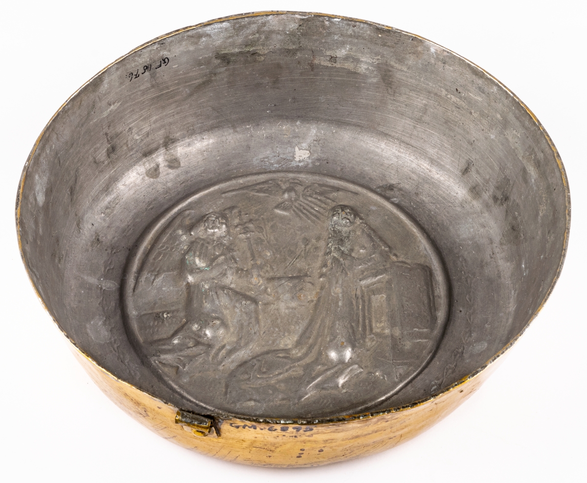Dopfat av förtent mässing, rund med reliefbild: Marie bebådelse.
Ursprungligen katalogiserad som puddingform, senare ändrat till dopfat.