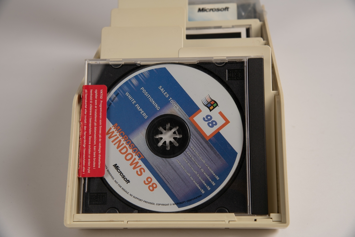 Hvit boks med gjennomsiktig lokk. Inneholder 11 CD-er. CD-ene inneholder ulike programvarer. 
Er også to etuier til CD-plater.