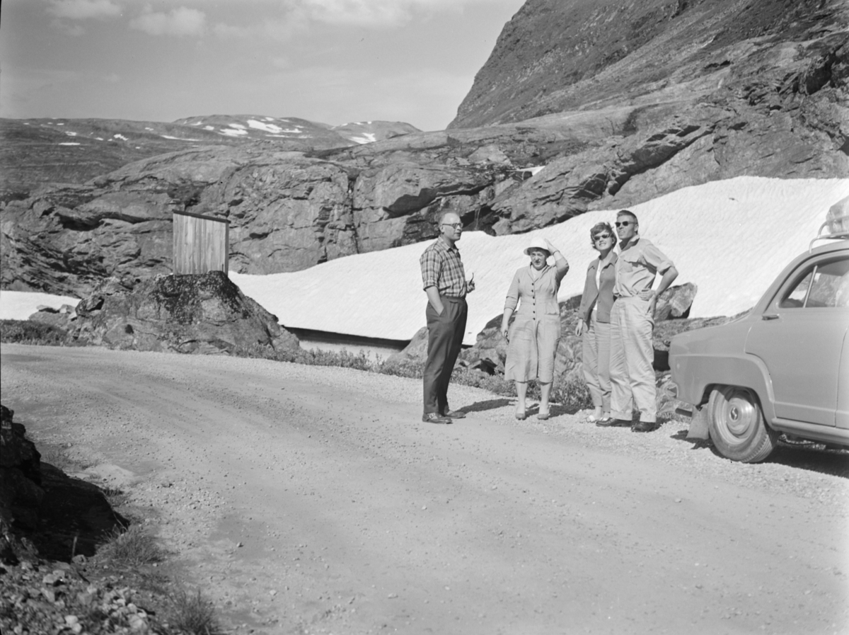 Strynefjellsvegen omtrent ved Grotli. I bakgrunnen et skur brukt ved mylding (molding). Antageligvis Magne Skotte og Rønnaug Holstad til høyre.