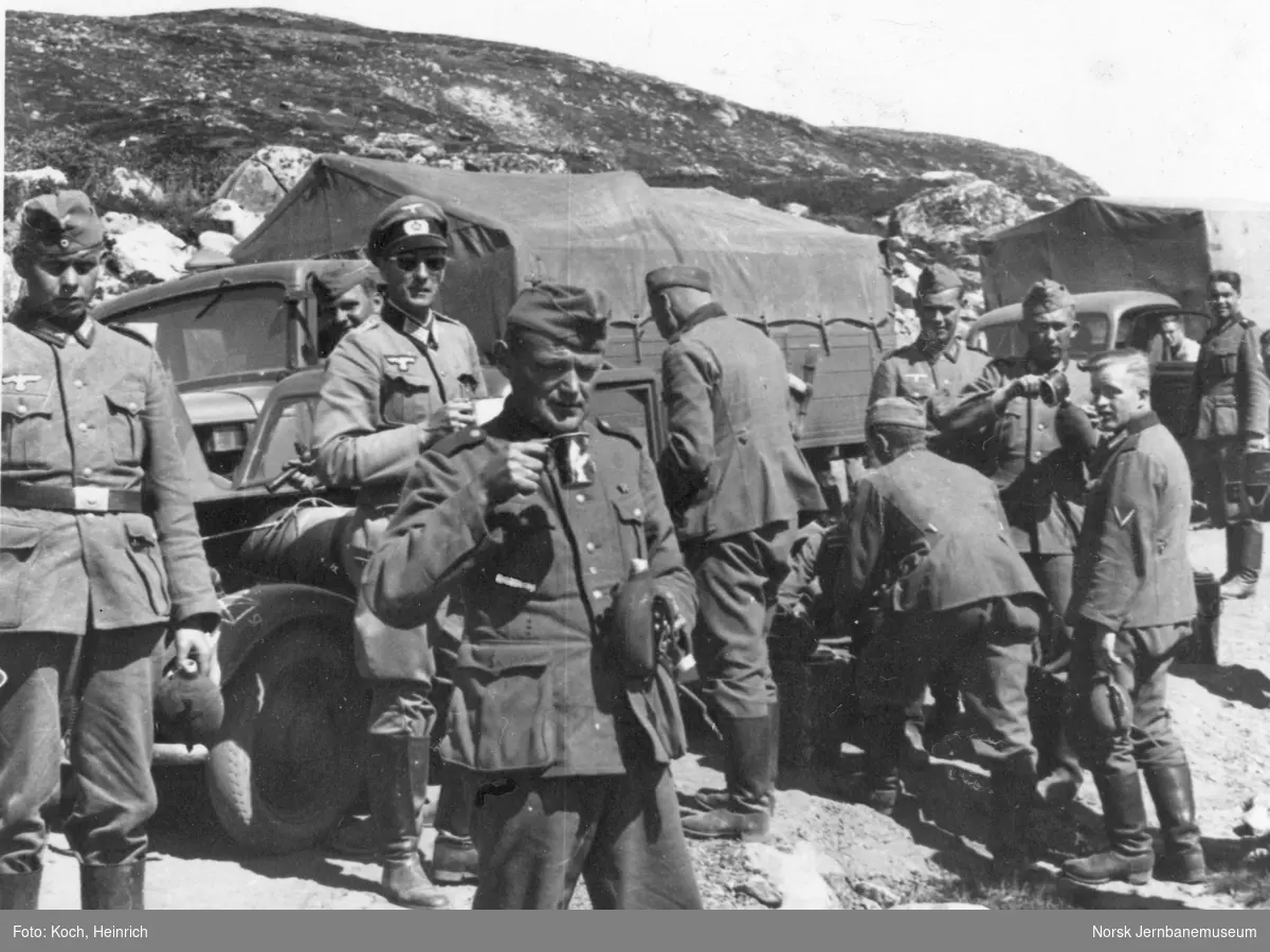 Kolonne med kjøretøy tilhørende den tyske okkupasjonsmakten har stanset og soldatene tar en pause, underveis over Hardangervidda