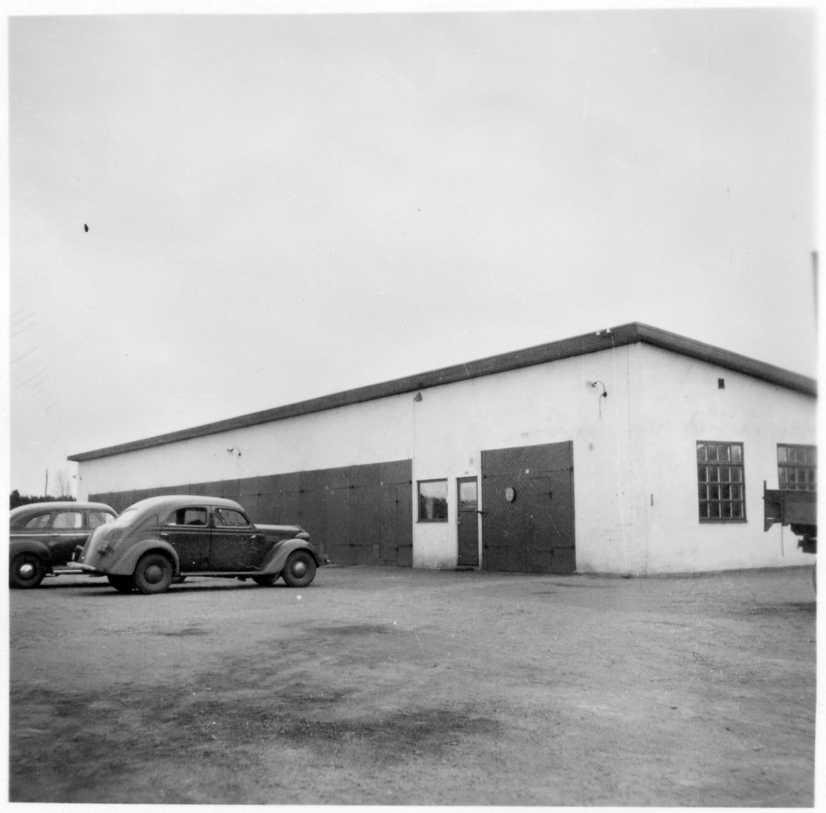 Vägstation H6, Målilla. Garage- och verkstadsbyggnad. Två personbilar på garageplan.