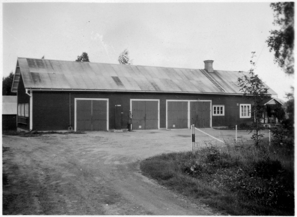 Vägstation Vmo X4, filial Arbrå. Förrådsbyggnad, med upplag vid gaveln av bränslefat.