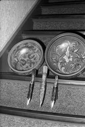 Rosemalte trefat og kniver med slire står oppstilt i trappen