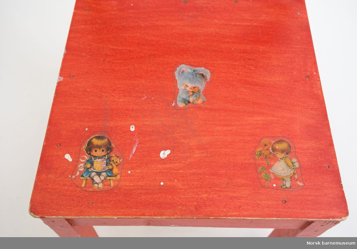 Rødmalt hjemmelaget furustol med klistermerker og påskrift "Cecile, 1982". Kryssfiner av bjørk i sete. Reparet i akterstavene.