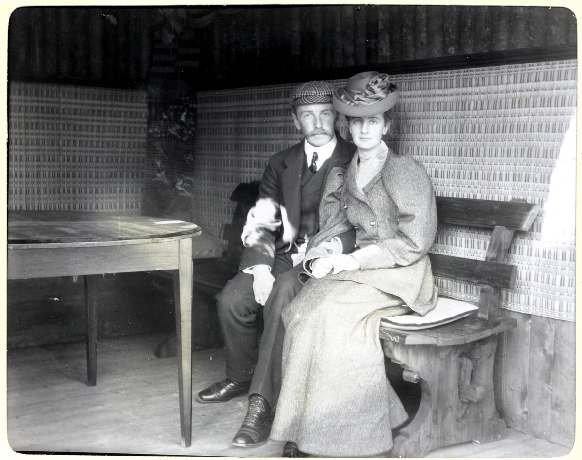 Nygifte Nini og Westye Egeberg på en benk i lysthuset på Egeberg-familiens Strøm gård, antagelig Vestre Strøm gård i Rælingen. Fotografert 18. september 1904.