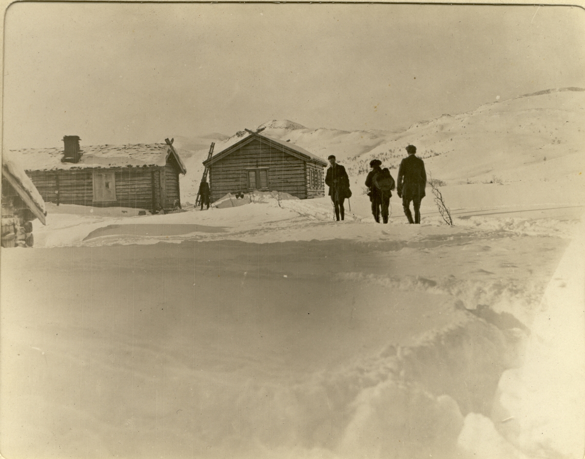 Fire skiturister utenfor turisthytten Bessheim i Jotunheimen. Fotografert mars 1908.